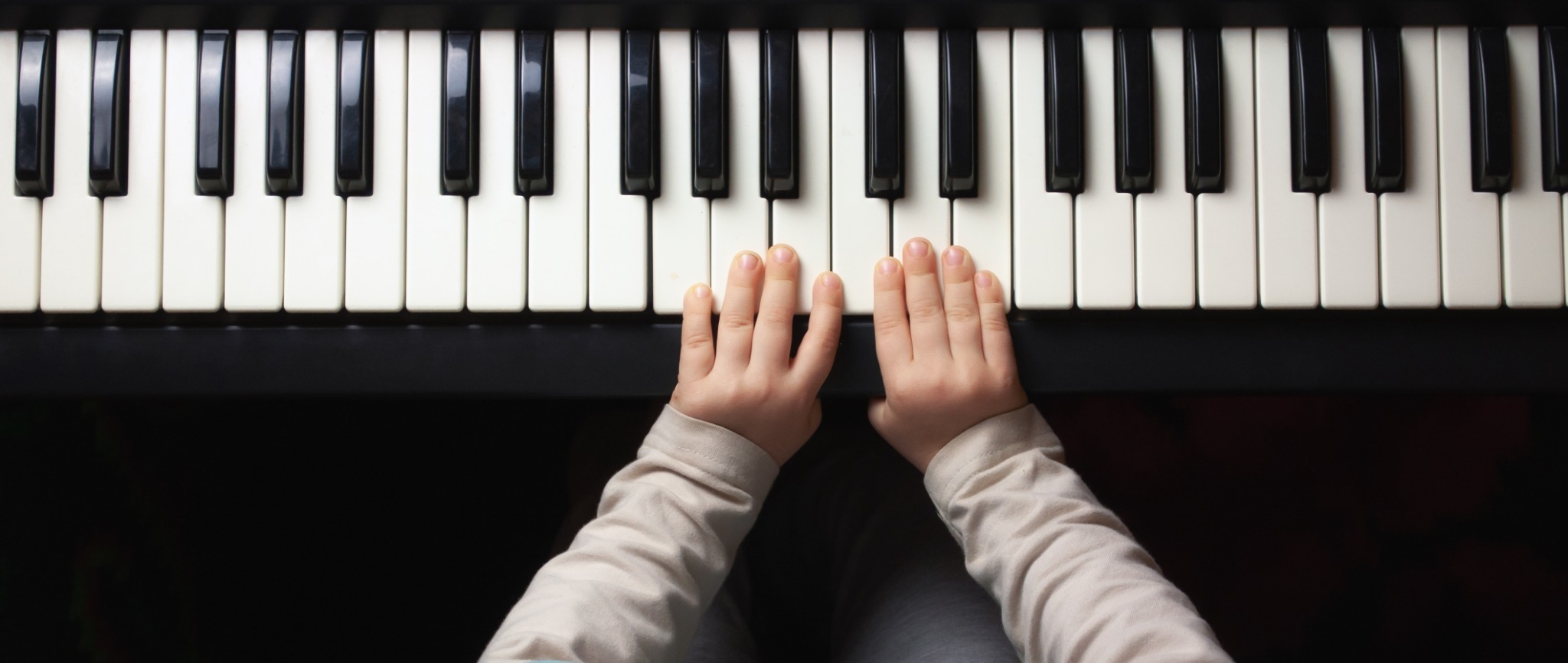 Small hands practising on a piano keyboard